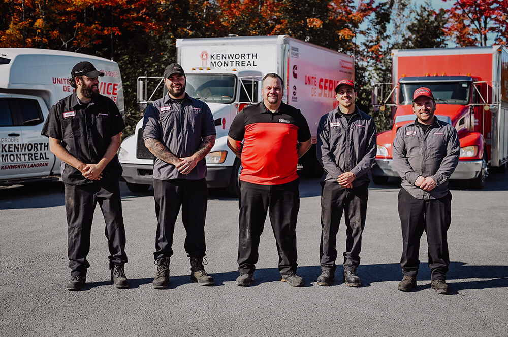 Certified technicians standing in front of the 3 Groupe Kenworth Montréal mobile units.